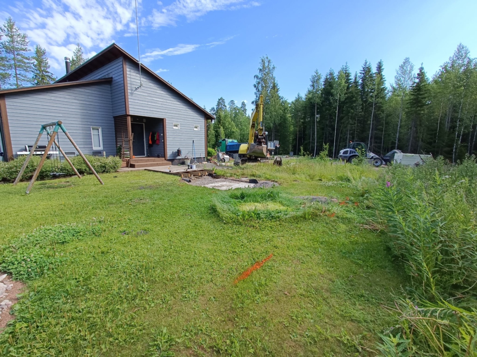 Pyöräkuormaaja ja kaivinkone pihakohteen maanrakennustyössä